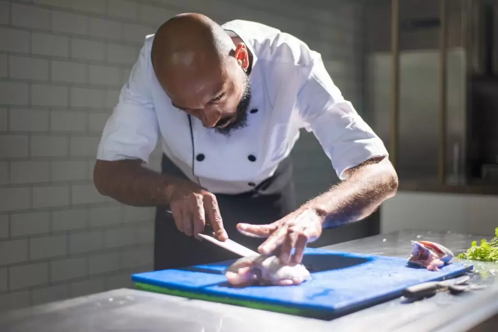 Chef Demonstrating Knife Skills while Fileting a piece of Fish